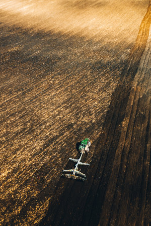 Aerial View. Tractor Plowing Field In Spring Season. Beginning Of Agricultural Spring Season. Cultivator Pulled By A Tractor In Countryside Rural Field Landscapeの写真素材