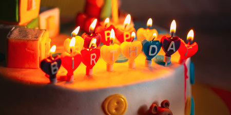 Happy Birthday Written In Lit Candles On Colorful Cake