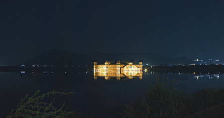 Jaipur, Rajasthan, India. Jal Mahal Or Water Palace In Night Illumination. Palace Inmiddle Of Man Sagar Lake. Was Originally Constructed Around 1699. Jal Mahal Palace Is Architectural Showcase Of Rajput Style Of Architecture. Night Calm Waterの写真素材