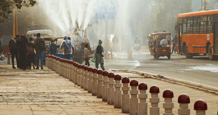 New Delhi, Delhi, India. Fire truck spraying water over Delhi streets amid pollution emergency. The government plans to spray the city with water in an attempt to clear the toxic smog cloud.のeditorial素材