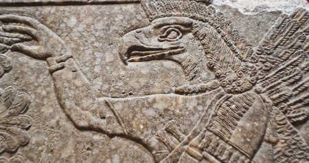 Close-up view on Eagle-headed Winged Figure And Sacred Trees. Architectural Fragment Of Panel From Northwest Palace Of Ashurnasirpal Ii By Neo Assyrian Period. Winged Bird Divine Spirit. Symbol Of Abundance And Prosperityの写真素材