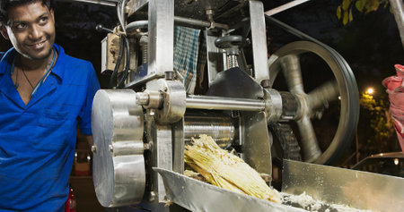 Mumbai, India. Sugarcane Juicer. Man Squeezes Sugarcane Through Press To Get Drink Sugarcane Juice. Man Making Sugar Cane Juice. Sugarcane Juice Is Liquid Extracted From Pressed Sugarcane. Very Popular Drink In India, Especially During Summer Months, As Rのeditorial素材