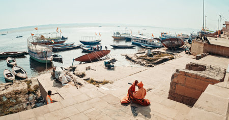 Varanasi, Uttar Pradesh, India. Indian Sadhu preparing for morning meditation and spiritual practice. Indian holy man sitting on the ghat at morning. Raja Ghat Ganges river.のeditorial素材