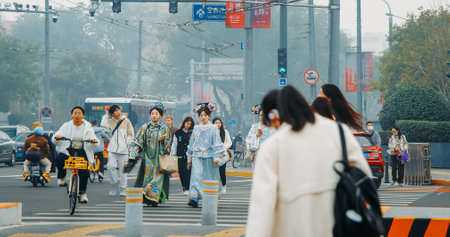 Beijing, China. Pretty Girls In Traditional Chinese Dresses Walk Along Street In Beijing. Girls In National Chinese Dresses Cross Road. Pedestrians Crossing Street. Traditions And Modernity. National Color. Traffic Street In Beijing. Asian Cultureのeditorial素材