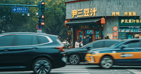 Beijing, China. Traffic On Gulou East Street In Beijing. Many Electric Cars On Road. Cars Moving On Street In Evening. Michelin Restaurant On Background. Michelin Guides. City Life. City Trafficのeditorial素材