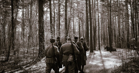 Squad Men Dressed As World War II Russian Soviet Red Army Soldiers Marching Through Spring Forest In...