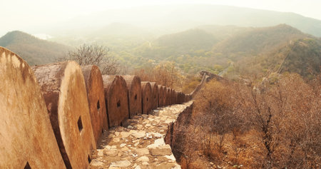Jaipur, Rajasthan, India. Fortress Wall Surrounding Amer Fort Or Amber Fort, Amer Situated On Forested Hill. Bright Sunset Sky. Great Example Of Rajput Architecture. Popular Tourist Attraction In Jaipur. Travel To India. Included In Unesco World Heritage Site Listの写真素材