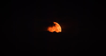 Full orange moon Moonrise in Dark Night cloudy Sky natural Background. nighttime Yellow Moonの写真素材