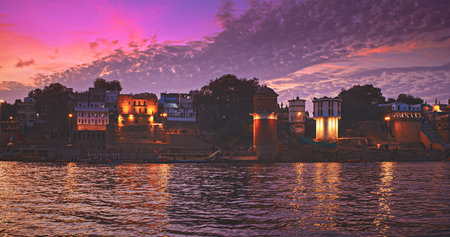 Varanasi, India. Many Boats Moored On Ganga River Near Ghats. Camera Moving Along Riverbank Embankment. General View On Lassi Ghat, Tulsi Ghat and Bhadaini Ghat. Purple Sunset Sky At Evening . Evening At Sacred Varanasi Ghatsの写真素材