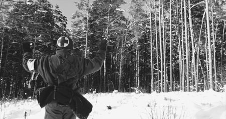 Historical Re-enactment Black And White . 4K Re-enactor Dressed As American Soldier Medic Of USA Infantry Of World War II Come Out Of Ambush With Hands Up Surrender To Captivity In Winter Dayの写真素材