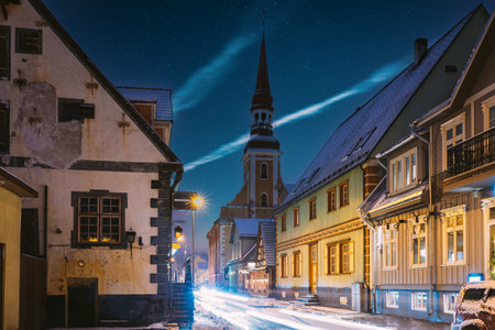 Parnu, Estonia. Night View Of Kuninga Street With Old Houses, Restaurants, Cafe, Hotels And Shops In Evening Night Illuminations. View Of Lutheran Church Of St. Elizabeth On Backgroundの写真素材