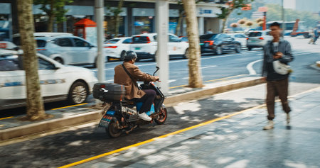 Bike Scooter Rider on Electric Scooter in Busy Urban Scene Amidst Fast Traffic Shanghai, China