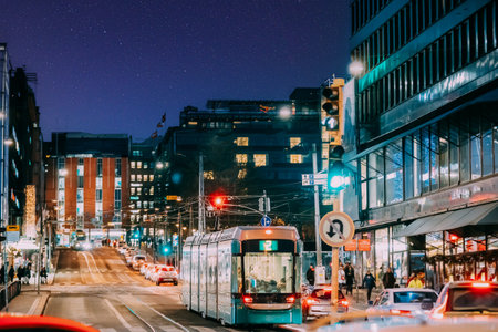 Helsinki, Finland. Tram Departs From A Stop On Kaivokatu Street In Helsinki. Night View Of Kaivokatu Street In Kluuvi District In Evening Or Night Illumination. Starry sky above scene. Night stars shining above streetの写真素材
