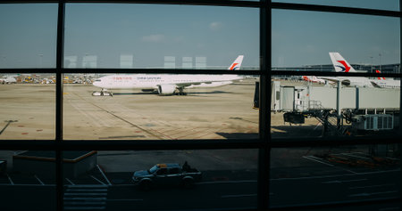 China Eastern Airlines aircraft at airport apron seen through terminal windowのeditorial素材