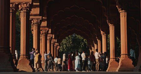 Red Fort Delhi colonnade with decorative arches and tourists exploring historic architectureのeditorial素材
