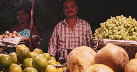Indian vendor selling fresh fruits at night street marketのeditorial素材