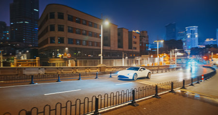White supercar in fast motion at night. urban street scene with moving cars and modern architecture illuminated at nightの写真素材