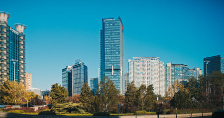 Beijing skyline with modern high-rise buildings, urban park and autumn landscape under blue sky