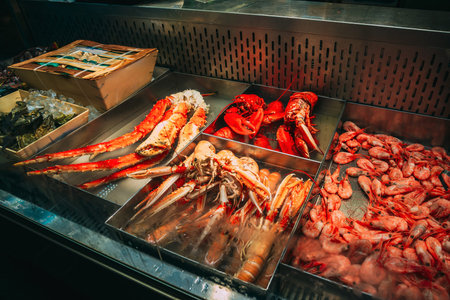 Trade in seafood seafood in the local Market. Close-up of a gourmet seafood display with lobsters, crabs, and fresh fish on ice at indoor market hall. Close-up of a gourmet seafood display with lobsters, crabs, and fresh fish on ice