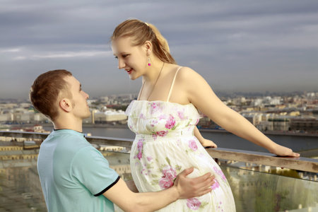 Happy couple on the roof of a high building, with views of the big city.