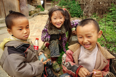 GUIZHOU, CHINA - APRIL 10: Ethnic Minorities in China, Three Chinese children, aged 10 years, chatting in a village street, April 10, 2010. Basha Village, Congjiang County.のeditorial素材