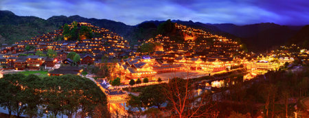 Xijiang village, Guizhou, China - April 17, 2010: Xijiang miao village, the largest village in Guizhou Miao ethnic minority, April 17, 2010. Night illumination of houses and a bridge over a river village in Xijiang Town. Leishan County.のeditorial素材
