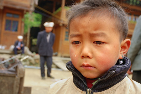 Zengchong village, Guizhou, China - April 12, 2010: Rural areas in southwest China, a boy 8 years of is upset tears on his face, Zengchong Dong ethnic minority Village,, Guizhou province, Southwestern China - April 12, 2010:のeditorial素材