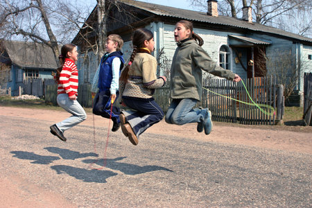 Tver, Russia - May 2, 2006: Russian, rural junior schoolchildren during recess, jumping rope, on the road near the schoolのeditorial素材