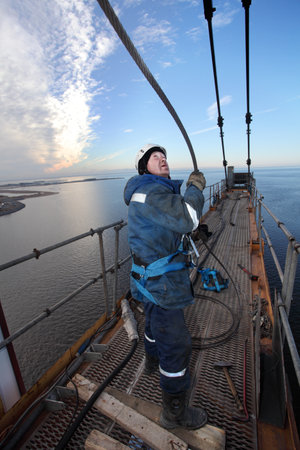 St. Petersburg, Russia - October 30, 2014: Steeplejacking Erector is working at height when installing console section of the tower crane. High-altitude installation work working console tower crane.のeditorial素材