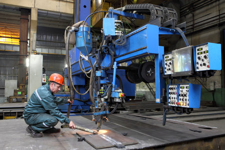 St. Petersburg, Russia - October 10, 2014: Industrial processing metal, automated submerged arc welding process. Work controls the setting for butt welding of steel sheets, metal working machine.のeditorial素材