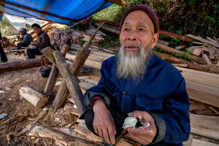 Langde Village, Guizhou, China - April 16, 2010: Langde Shang ethnic minority Miao Village, elderly asian man eating boiled chicken egg.のeditorial素材