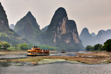 Yangshuo, Guangxi, China - March 29, 2010: Cruise ship packed with tourists travels the magnificent scenic route along the Lijiang River from Guilin to Yangshou. southern China.のeditorial素材