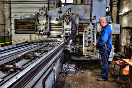 St. Petersburg, Russia - May 21, 2015: Heavy duty planer type milling machine for planing, grinding, milling, boring large metal parts, working machine operator controls the processing of metal.のeditorial素材