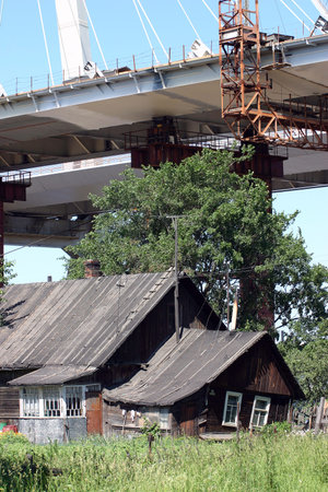 Novosaratovka Village, St. Petersburg, Russia - July 2, 2006: Construction of the cable-stayed bridge over the residential farmhouse in the Russian village.のeditorial素材