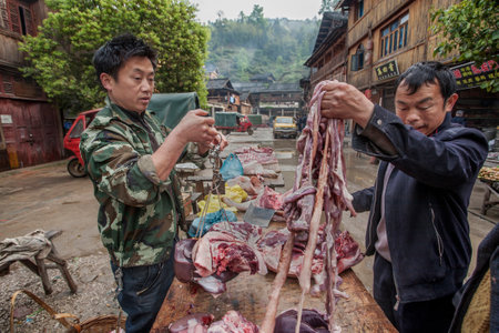 Zhaoxing Dong Village, Guizhou Province, China -  April 8, 2010: Asiatic buying pig entrails from a street vendor in the Chinese countryside.のeditorial素材