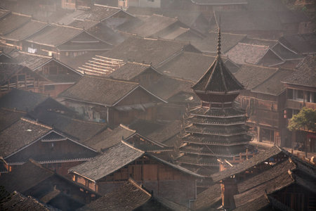 Zhaoxing Dong Village, Guizhou Province, China -  April 9, 2010: Tile roofs of wooden houses of Chinese peasants in the village of Dong ethnic minority in southwest China, early misty morning, spring.のeditorial素材