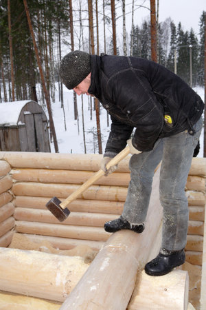 Leningrad Region, Russia - February 2, 2010: Handyman aligns a wall with a sledge hammerのeditorial素材