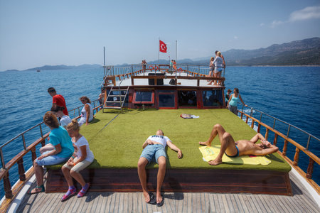 Antalya, Turkey - 28 august, 2014: Tourists rest on an artificial green coating, on the deck of a sightseeing boat.のeditorial素材
