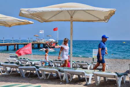 Antalya, Turkey - 29 august, 2014: A family of three people walks along a deserted beach.のeditorial素材