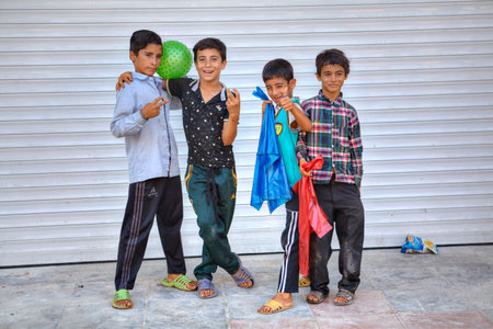 Bandar Abbas, Hormozgan Province, Iran - 16 april, 2017: Four boys of teenage friends twisted and gesticulated at the sight of a tourist with a camera.のeditorial素材