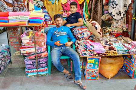Bandar Abbas, Hormozgan Province, Iran - 16 april, 2017: Two young Persian men trade textiles in the Grand Bazaar.のeditorial素材