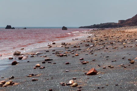 Beach with silver sand and red sea water on Hormuz Island, Hormozgan Province, Iran.の写真素材