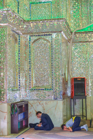 Fars Province, Shiraz, Iran - 18 april, 2017:  Mirrored mausoleum in Sayyed Alaeddin Hossein Mosque, Muslims pray and read the Koran.のeditorial素材