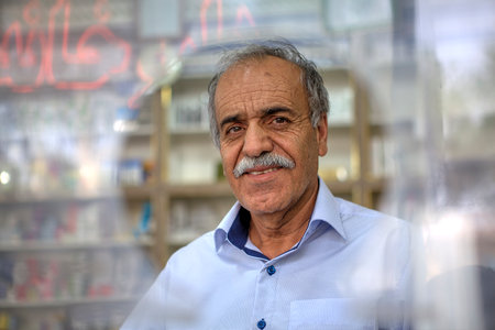 Fars Province, Shiraz, Iran - 18 april, 2017: Elderly man standing in front of round window on city street.のeditorial素材