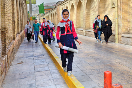 Fars Province, Shiraz, Iran - 18 april, 2017: Iranian schoolgirl in uniform goes home after school.のeditorial素材