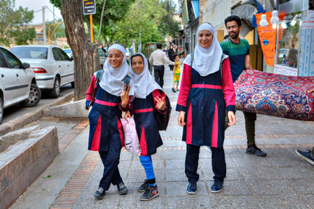 Fars Province, Shiraz, Iran - 18 april, 2017: Three Iranian schoolgirls in school uniform with a white hijab on a city street.のeditorial素材