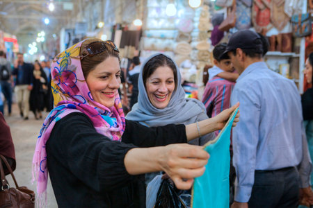 Fars Province, Shiraz, Iran - 19 april, 2017:  Two smiling Muslim women in colored hijab choose fabric to buy at the Vakil Grand Bazaar.のeditorial素材