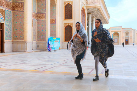 Fars Province, Shiraz, Iran - 19 april, 2017: Shah Cheragh Shrine, Two fashionable young Iranian women pass through the inner courtyard of the mosque.のeditorial素材