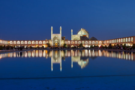 Isfahan, Iran - April 23, 2017: Night view of the pond with a fountain in the square Nagshe Jahan with reflection in the water of the Shah Abbas mosque with evening illumination of the facade.のeditorial素材