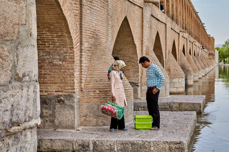 Isfahan, Iran - April 24, 2017: A man and a girl came to the bridge of Allahverdi Khan to have a picnic near the river Zayandeh.のeditorial素材